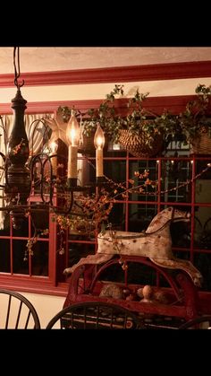 an old car is parked in front of a window with candles on the windowsill