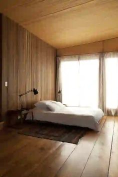 a bedroom with wooden walls and flooring