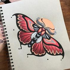 a drawing of a butterfly on top of a notebook