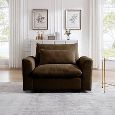 a living room with a chair and two pictures on the wall