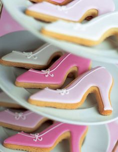 decorated cookies are arranged on plates in the shape of shoes