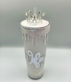 a shot glass with a tiara on top and the word life written in white