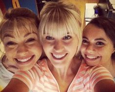 three women are taking a selfie with their cell phone in front of the camera