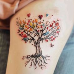 a woman's thigh with a tree and hearts tattoo on the side of her leg