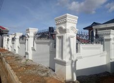 a white fence and some buildings in the background