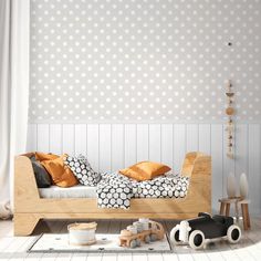 a child's bedroom with white polka dot wallpaper and wooden bed, toy cars and toys on the floor