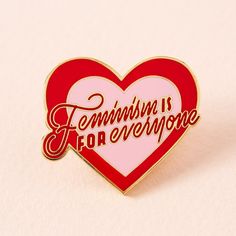 a red and white heart shaped pin with the words feminist is for everyone