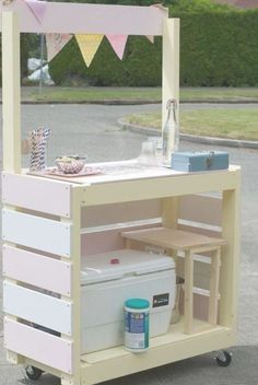 an outdoor ice cream cart is painted pink and white