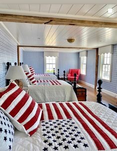 two beds with american flags on them in a room that has blue and white walls