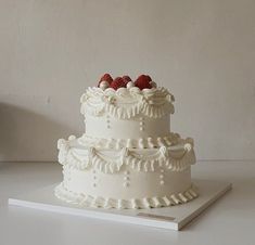 a three tiered white cake with raspberries on top