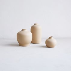 three white vases sitting next to each other