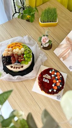 a table topped with a cake covered in fruit