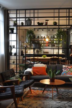 a living room filled with furniture and plants