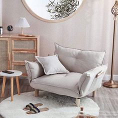 a living room with a round mirror on the wall and a white rug in front of it