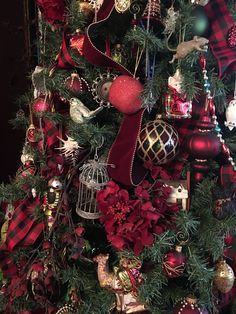 the christmas tree is decorated with red and gold ornaments