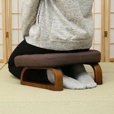 a woman sitting on top of a wooden chair