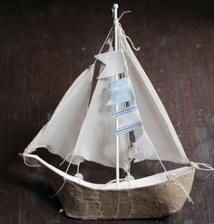 a small model sailboat sitting on top of a wooden table