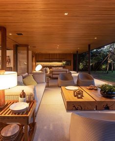 a living room filled with lots of furniture next to a wooden ceiling covered in windows