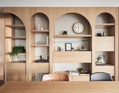 an office with wooden shelves and clock on the wall