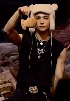 a young man wearing a hat and holding a stuffed animal