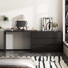 a black and white bedroom with a large mirror on the dresser next to it's bed