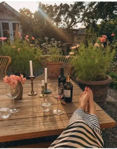 a person sitting at a wooden table with wine bottles and glasses