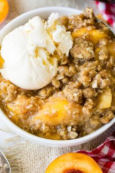 a bowl filled with fruit and ice cream next to sliced peaches on a table