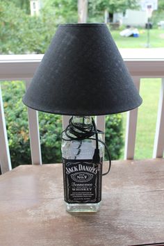 a lamp that is sitting on top of a table next to a jar with a bottle in it