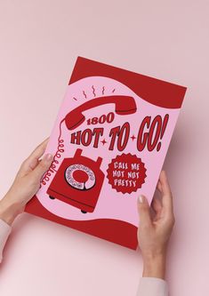 a person holding up a pink book with red lettering on it and an image of a hot - to - go machine