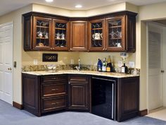 a kitchen with wooden cabinets and marble counter tops in an open floor plan, along with doors leading to another room