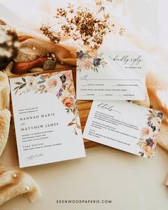 the wedding stationery is laid out on top of an old wooden box with dried flowers