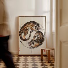 a tiger painting sitting on top of a black and white checkered floor next to a wooden stool