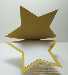 an origami star with a white background and gold border on the bottom corner