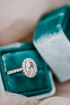 an engagement ring sits in a velvet box