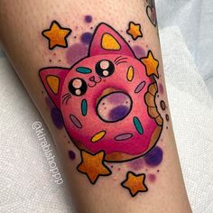 a pink donut with stars on it's leg is featured in this tattoo design