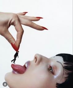 a woman with red nail polish on her face