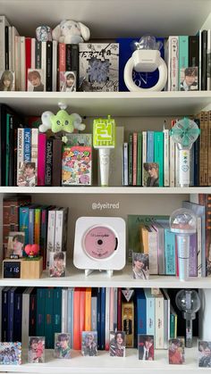 a bookshelf filled with lots of different types of books and stuff on top of it