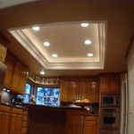 a kitchen with wooden cabinets and lights on the ceiling