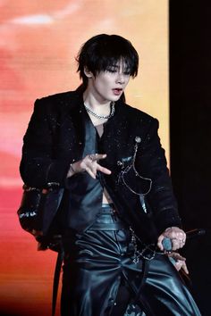 a man in black jacket and pants on stage