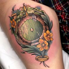 a woman's thigh with an image of a barrel and flowers on it