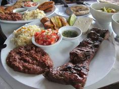 a plate with meat, rice and other foods on it