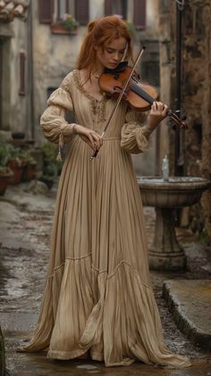 a woman in a long dress is playing the violin