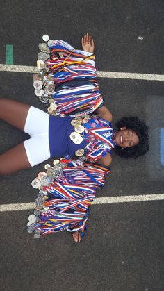 a woman is standing in the middle of a parking lot with medals on her skirt