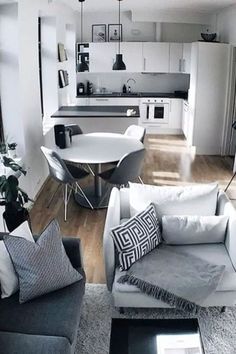 a living room filled with furniture next to a kitchen