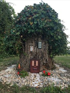 a house made out of a tree trunk with ivy growing on it's roof