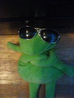 a green stuffed animal with sunglasses on it's head