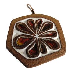 a brown and white object with oranges on it's side, hanging from a metal hook