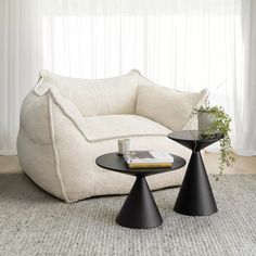 a white couch sitting next to a black table on top of a carpeted floor