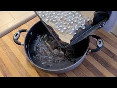 a pot filled with ice and water on top of a wooden table