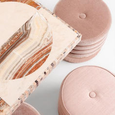 several round wooden coasters with pink marble designs on them and one has a piece of wood in the middle